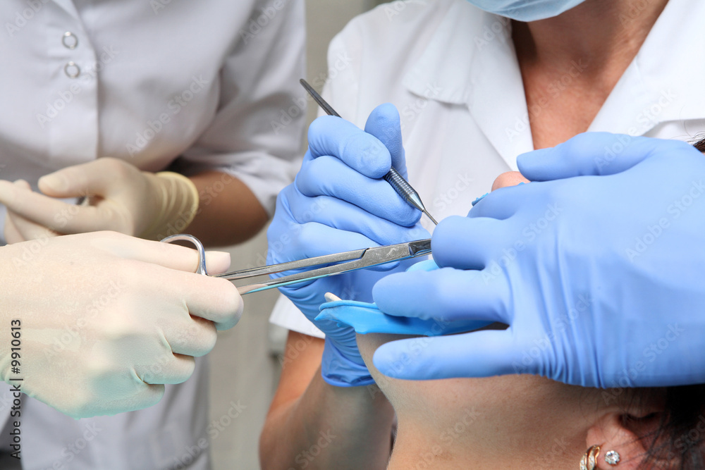 close up with hands in blue gloves and dental tools close up with hands in blue gloves and dental tools