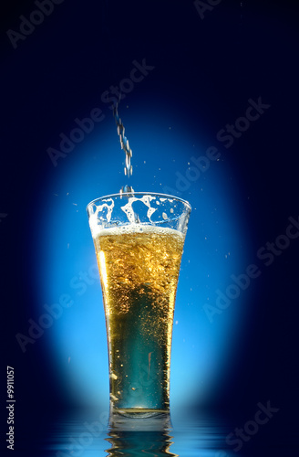 Wallpaper Mural Glass of beer  close-up with froth over blue background Torontodigital.ca