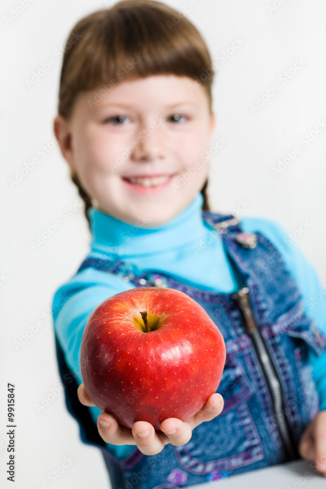 Close-up of fresh red apple in schoolgirl’s hand Close-up of fresh red apple in schoolgirl’s hand