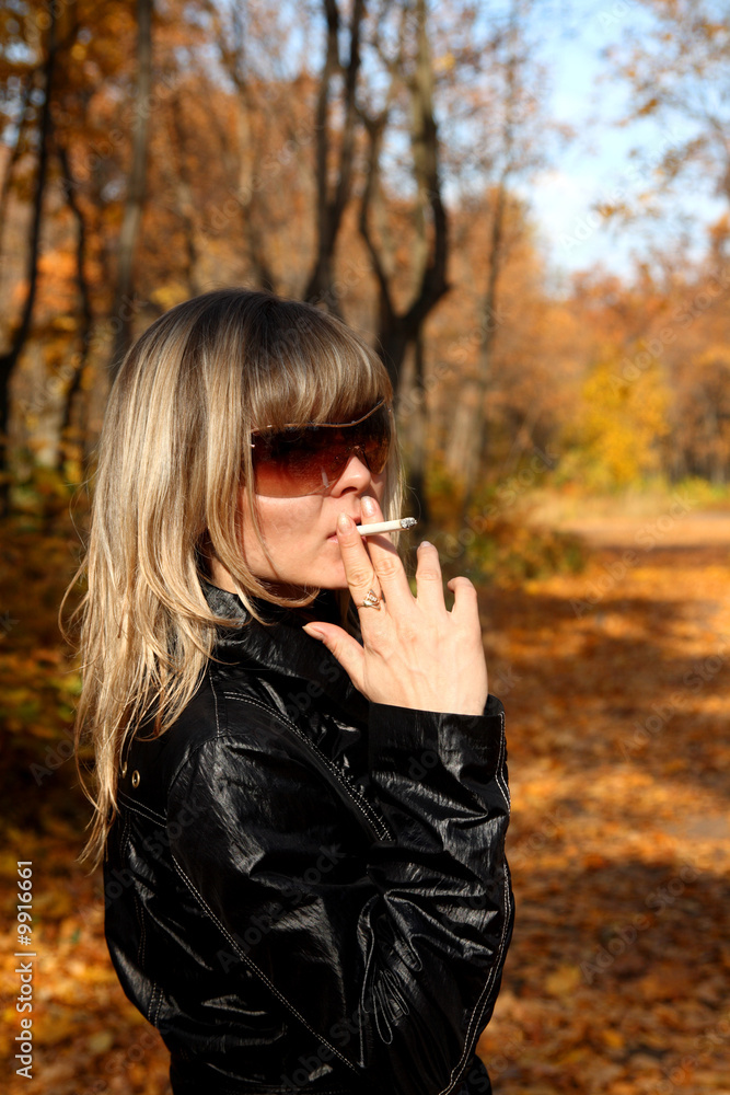 beautiful young girl with cigarette in autumn park beautiful young girl with cigarette in autumn park