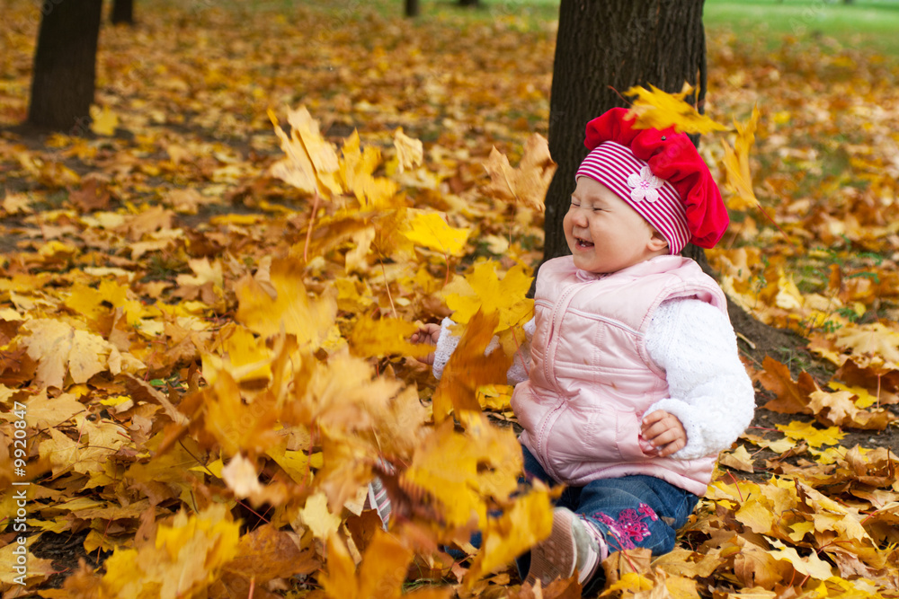 Laughing toddler and falling golden leaves Laughing toddler and falling golden leaves