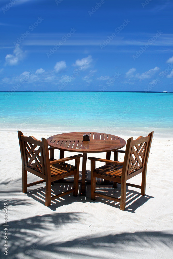 Table and chairs on exotic beach