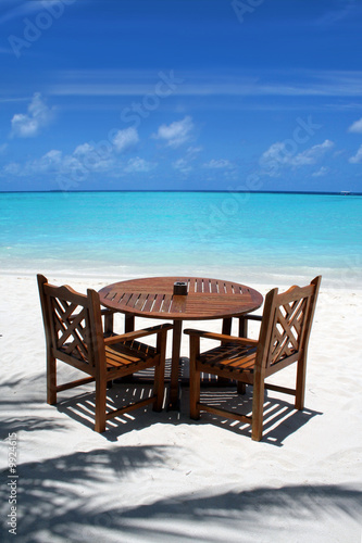Table and chairs on exotic beach