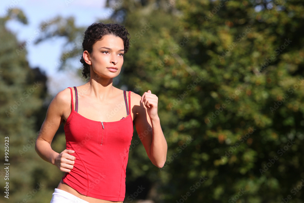 Beautiful girl running at speed through a park Beautiful girl running at speed through a park