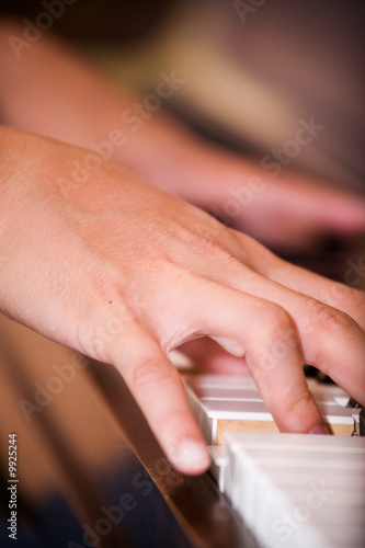 A closeup shot of a man practicing playing piano