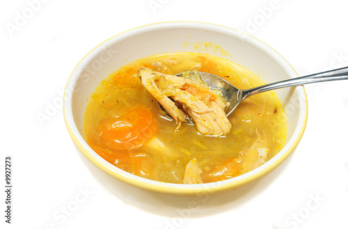 Chicken and vegetable soup in a bowl with spoon