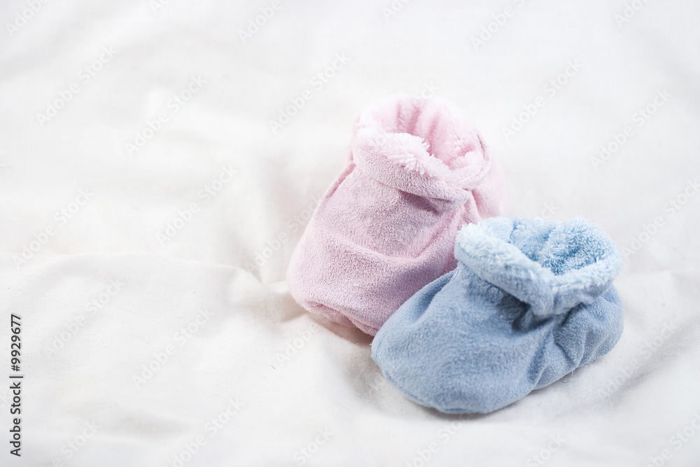 A pair of pink and blue baby shoes on a white background. A pair of pink and blue baby shoes on a white background.