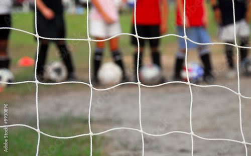 Obraz na plátně Kid players lined up behind soccer goal at practice