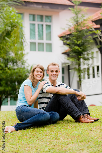 A young attractive couple sitting in garden of their house