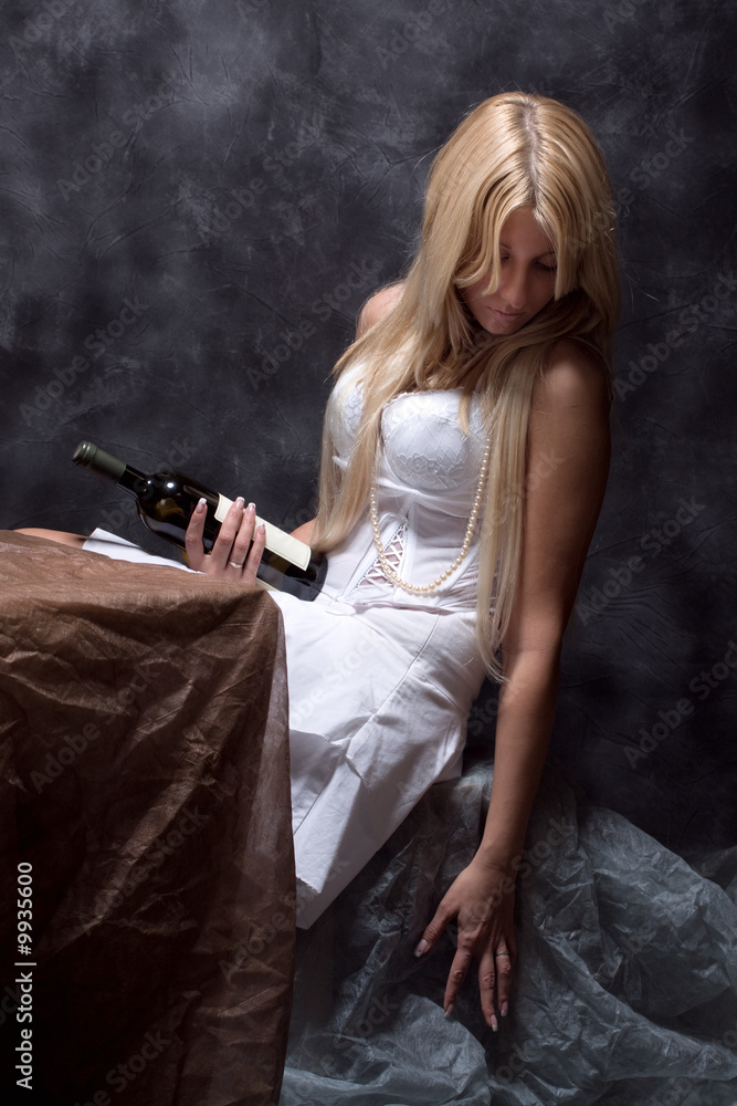 sad woman with bottle of wine, studio dark