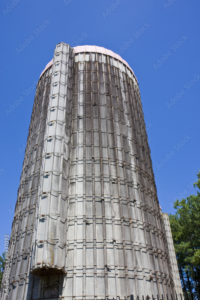 An old grain silo from the ground shot toward the blue sky