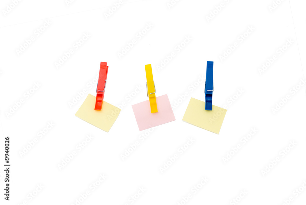 three pegs holding coloured scratch paper isolated on white three pegs holding coloured scratch paper isolated on white