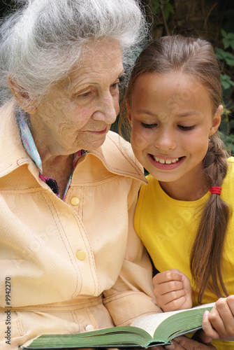 Granddaughter and her grandmother together reading a book