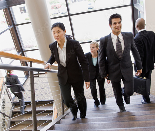 Fotografie Co-workers ascending and descending office stairs