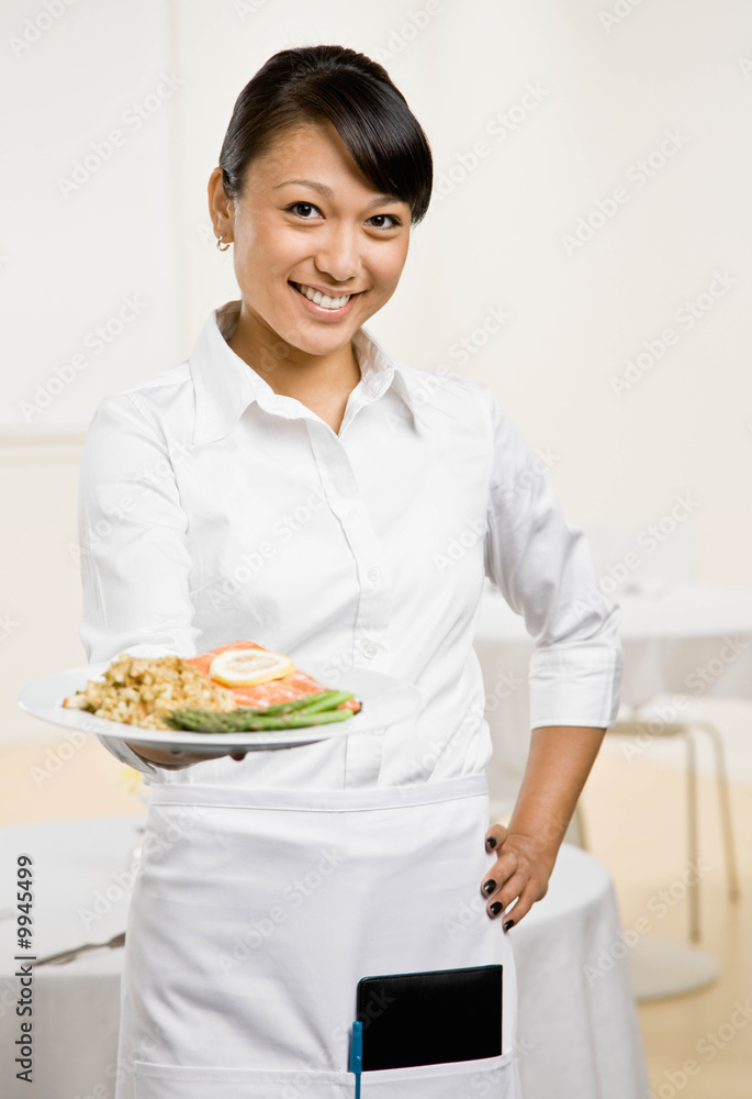 Waitress serving healthy dinner of salmon and asparagus Waitress serving healthy dinner of salmon and asparagus