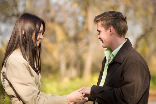 Young couple in love talking in the autumn park photo