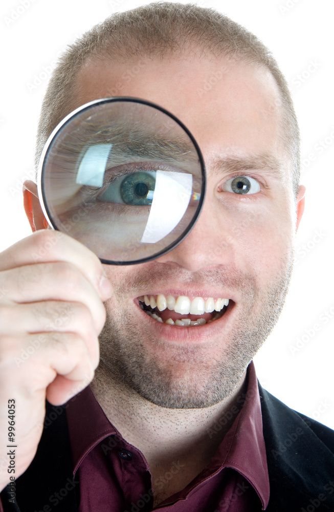 Businessman in a suit looks through a magnifying glass Businessman in a suit looks through a magnifying glass
