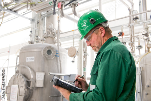 Middle aged industrial worker with notebook
