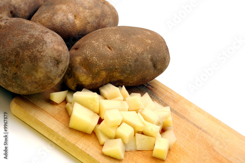 Whole and chopped fresh potatoes with copy space