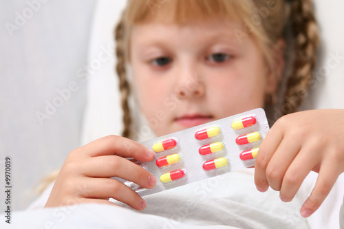 An image of a girl with pills in her hands