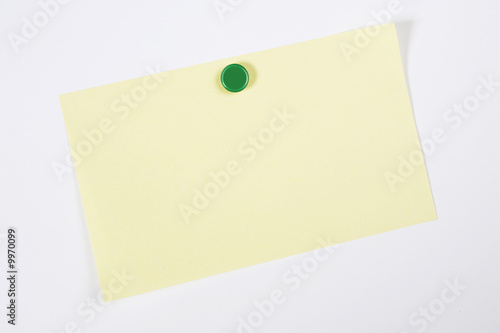 A blank yellow adhesive note pinned on to a white background