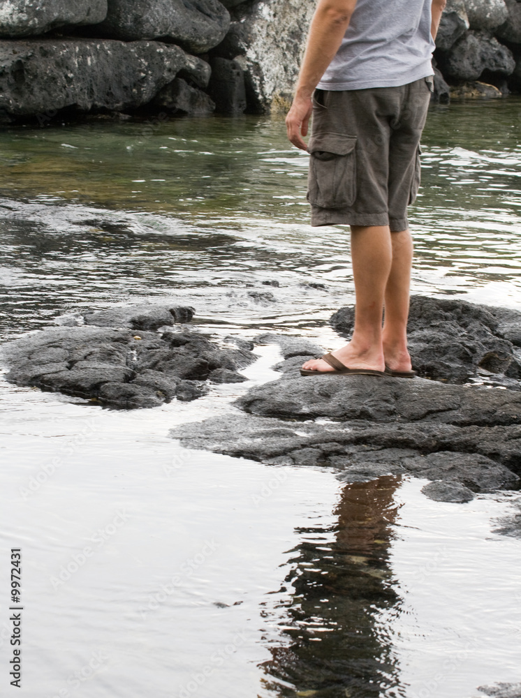 Man standing on lava rocks Man standing on lava rocks