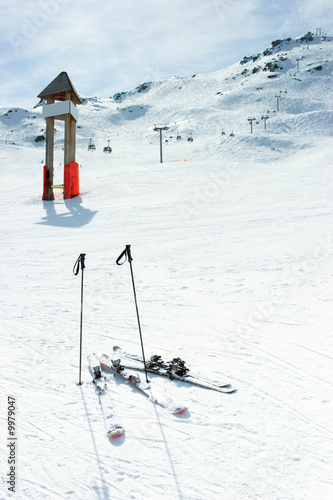 Blank signpost and skis on piste at ski resort