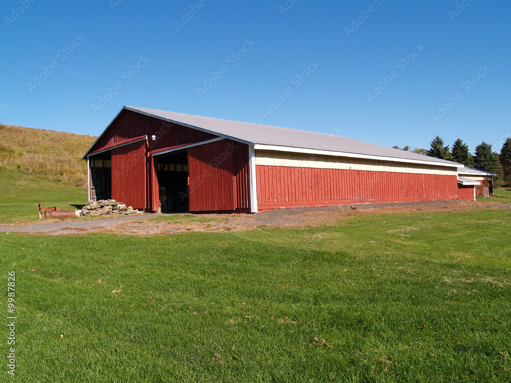 view of a large red barn in the country