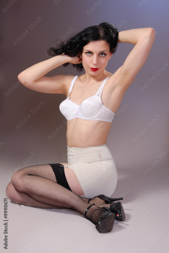Retro pin-up girl in vintage bra, girdle & fishnet stockings Stock Photo