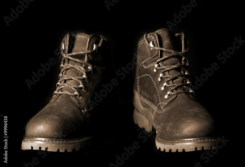 Pair of brown boots on black background.