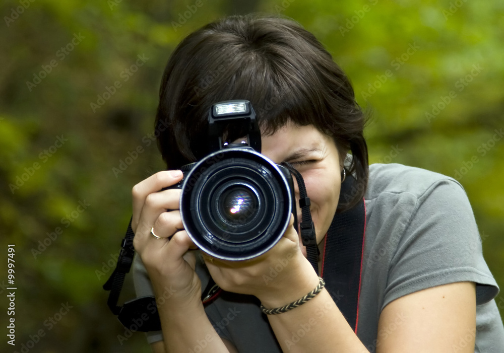Young female photographer in forest
