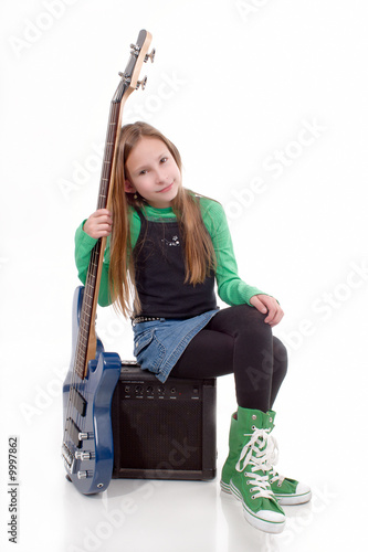 Young girl sat over an amplifier with a blue bass