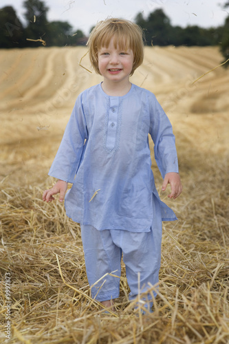 Canvas Print 3 year old playing in the straw on a summers day