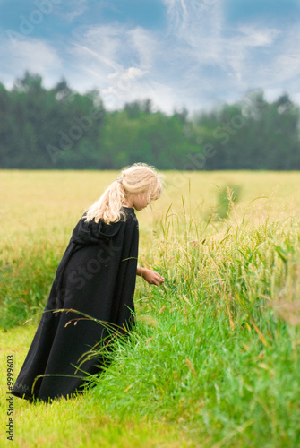 Blondes Mädchen mit Locken und Umhang