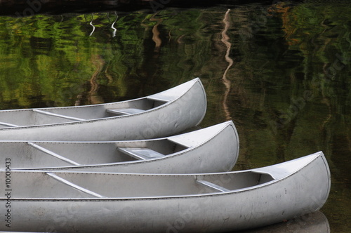 three silver canoes on a glassy lake Fototapet