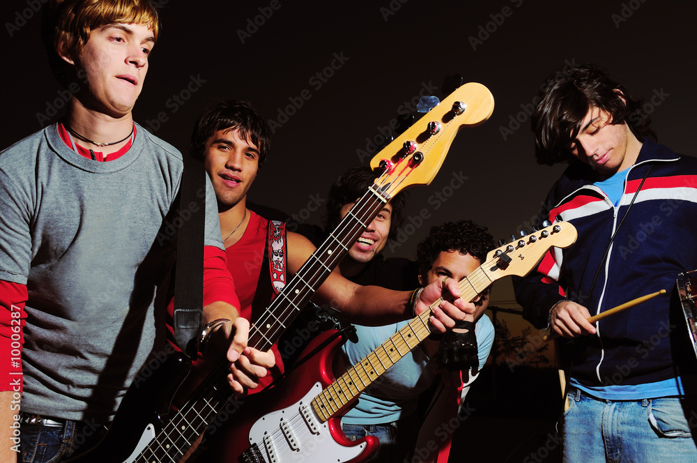 Obraz premium Portrait of young musical band with electric guitars