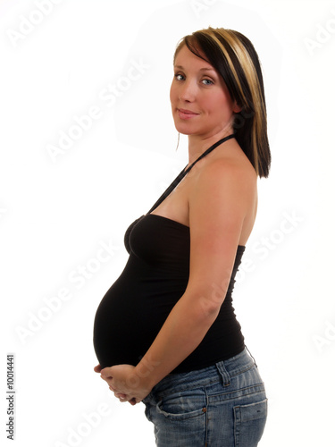 Young woman with large pregnant belly in top and jeans