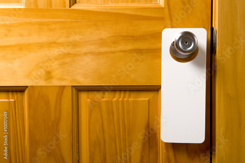 A blank door hanger on a door, with copy space photo