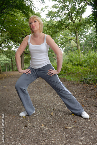 cute blond girl outdoors doing stretching exercises