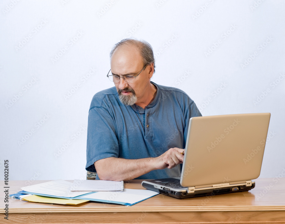 A businessman transcribes his notes onto the computer. A businessman transcribes his notes onto the computer.