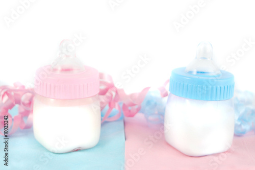 blue and pink baby bottles on napkins with colored ribbon photo