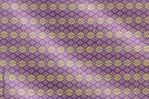 Intricate pattern of a purple and gold Songket cloth photo
