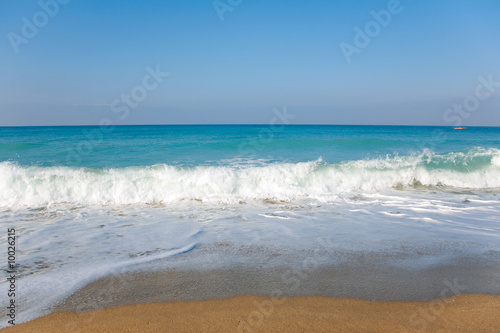 Scene of sky, sea, waves and sandy beach.