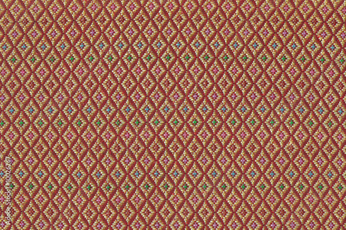Intricate pattern of a red and gold Songket cloth