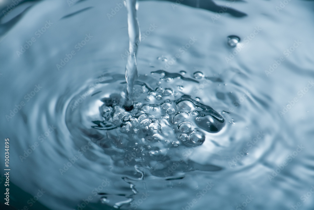 Water being poured producing bubbles and ripples Water being poured producing bubbles and ripples