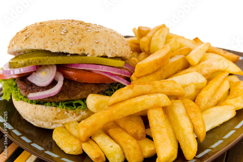 Hamburger with salad, pickle, onions, tomato and fries.