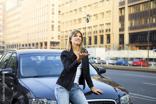 Obraz na plátně Young woman playing with keys of new car