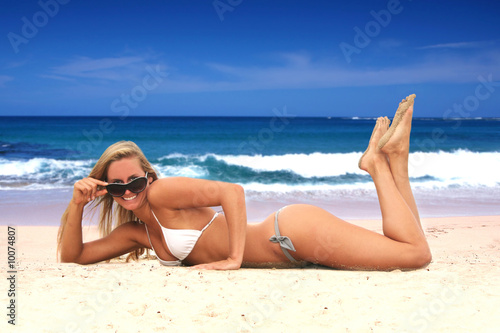 Beautiful Young Tanned Woman Lying on the Beach in White Bikini