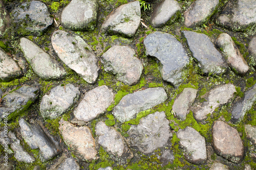 Old wall with moss among the stones