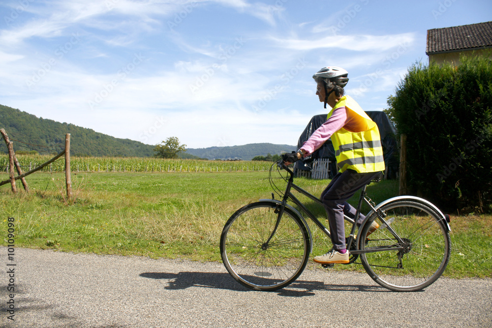 Fototapeta premium Female cyclist enjoying a ride in reflective safety clothes